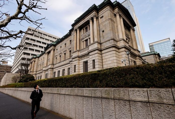 Seorang pria berjalan melewati kantor pusat Bank of Japan di Tokyo